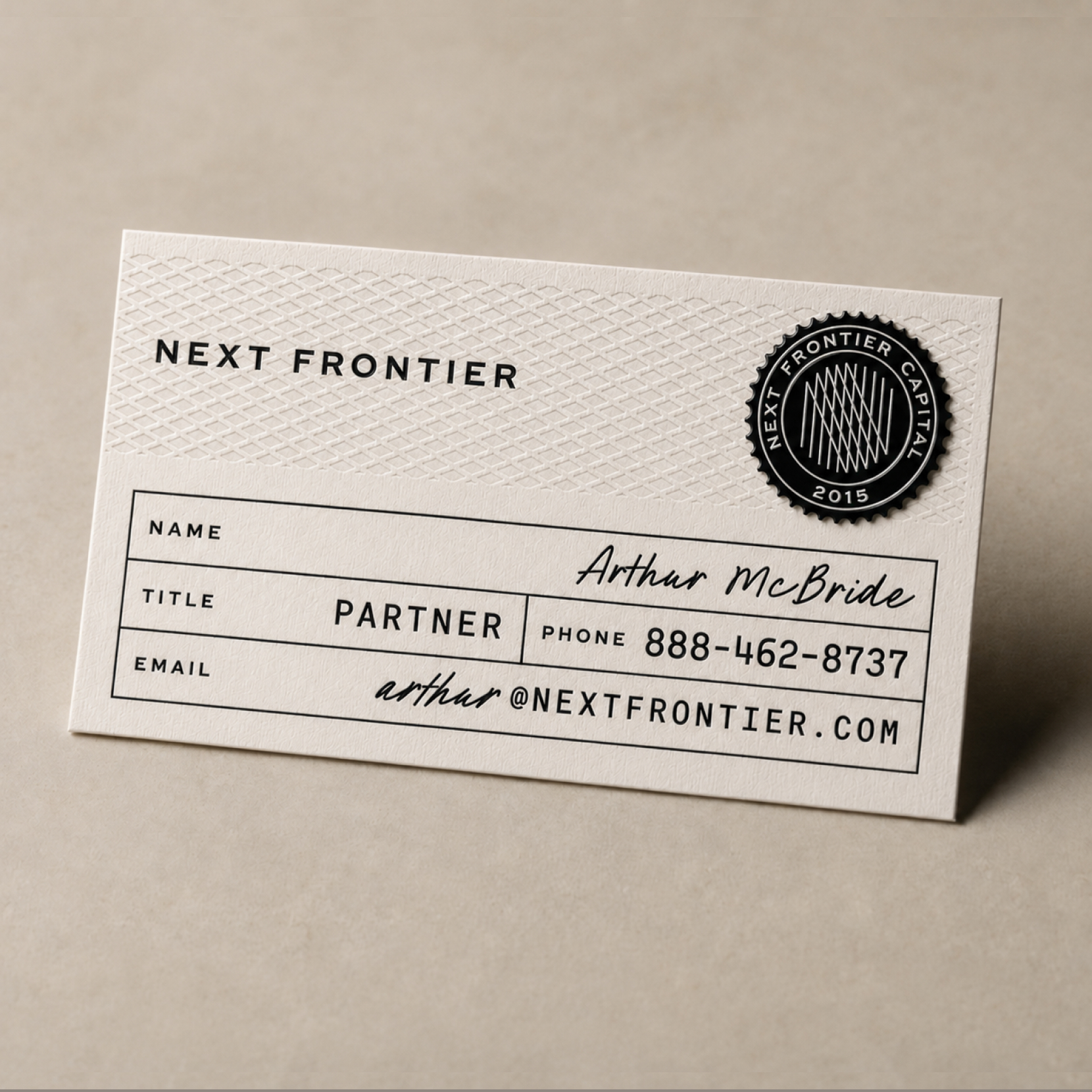 Next Frontier Capital business card pairing a restrained wordmark with a circular seal